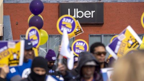 Uber and Lyft drivers rally to unionize in front of an Uber office in Saugus, Mass. on March 1. Photo by Bloomberg.