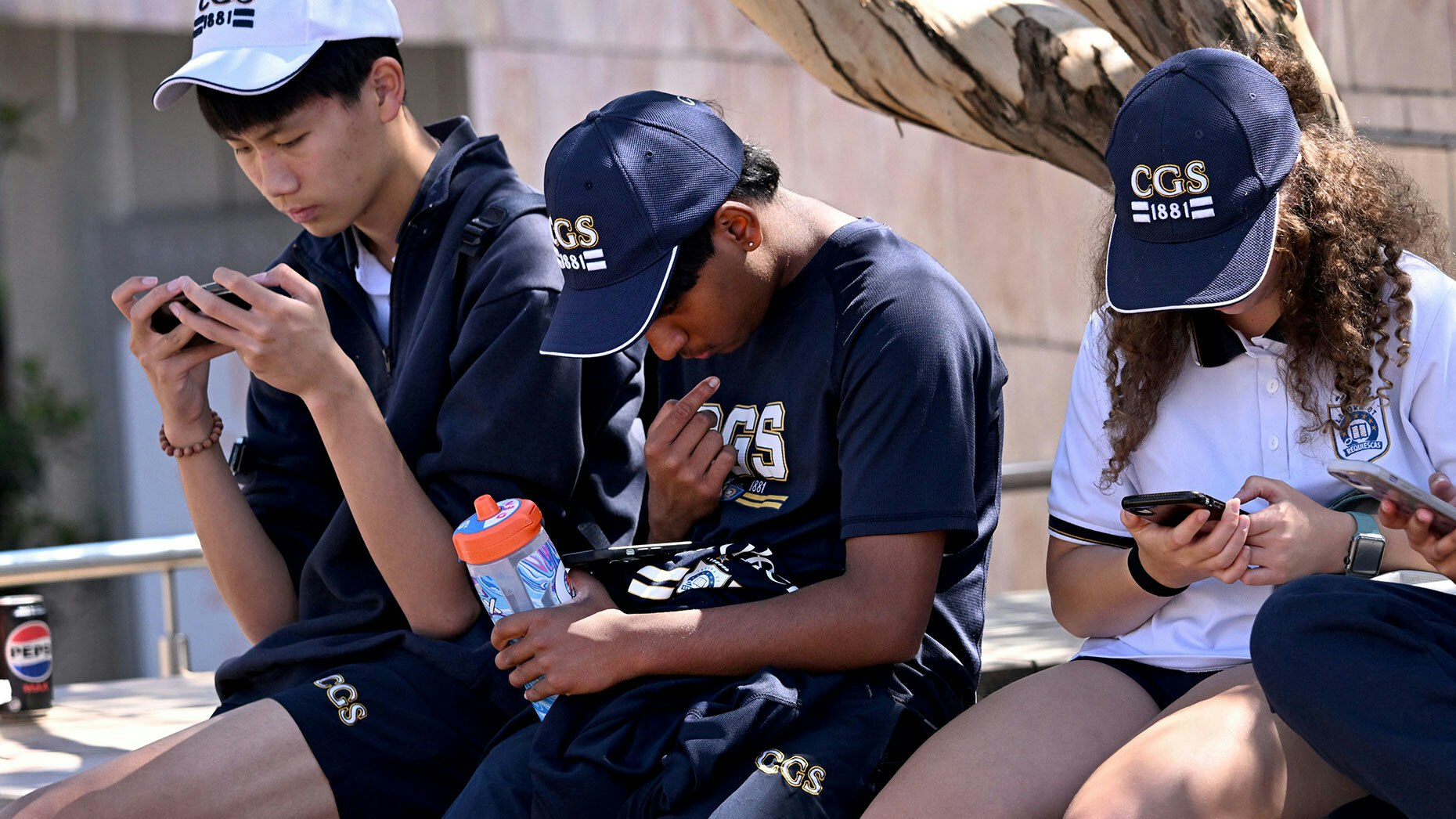 Teenagers in Melbourne, Australia, on their phones. Photo by Getty.
