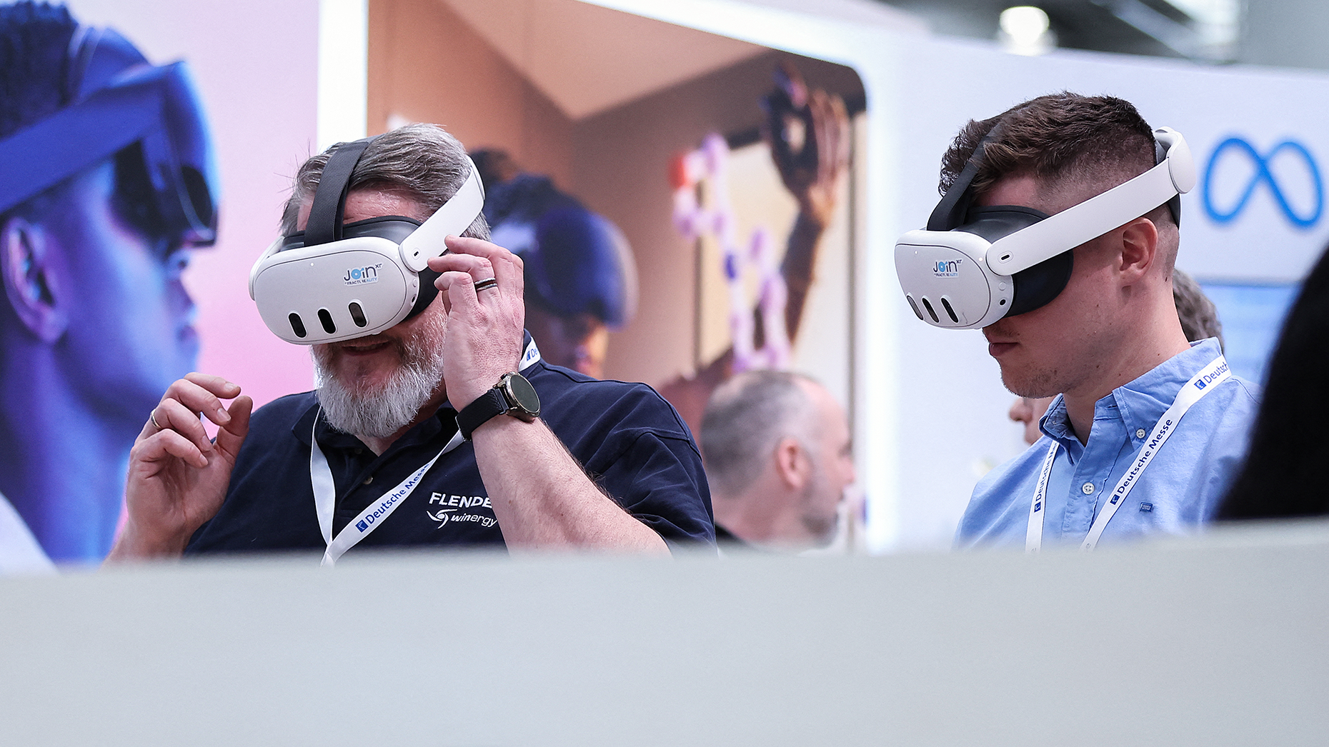 Visitors test Meta Quest 3 goggles at a Meta booth at the Hanover technology Fair in April. Photo by Getty