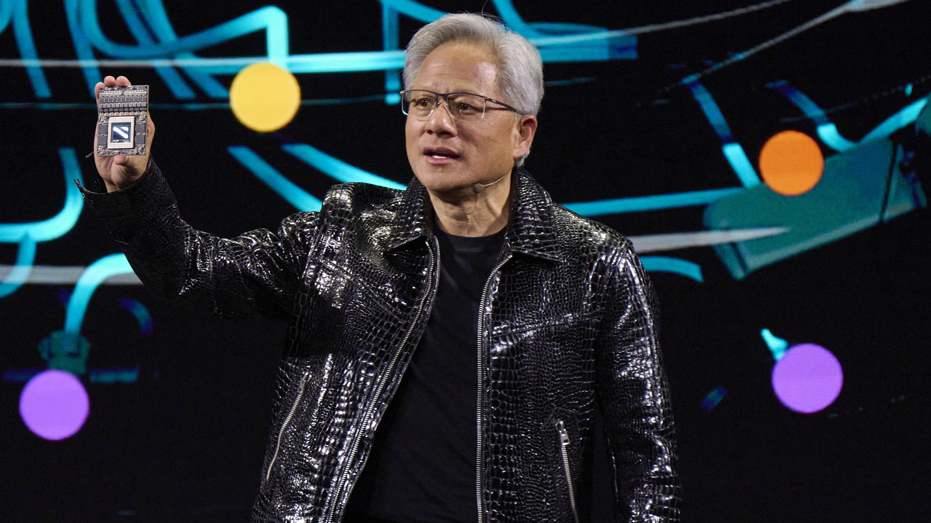 Nvidia CEO Jensen Huang holds a Thor Blackwell robotics processor. Photo by Getty.