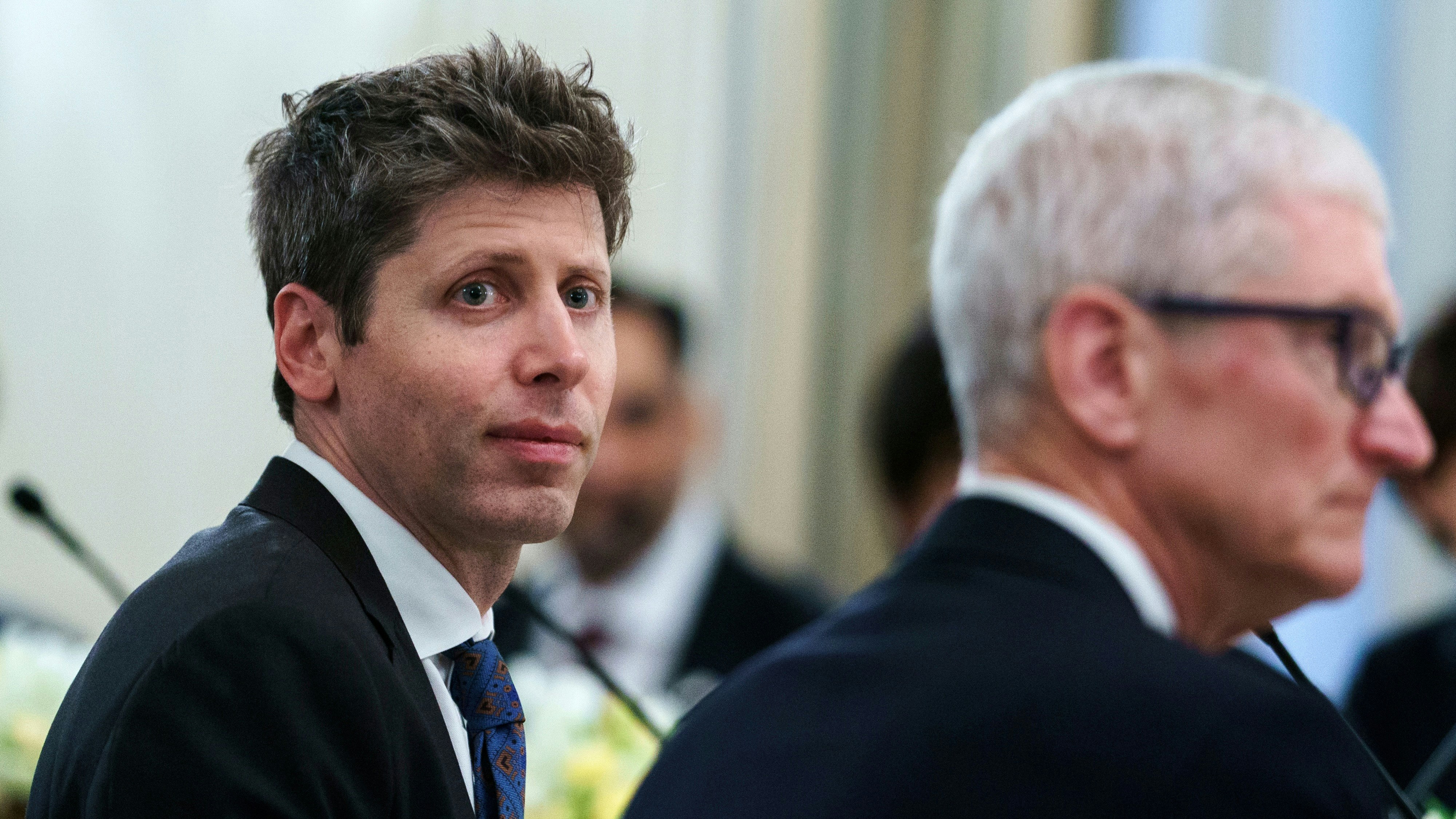OpenAI CEO Sam Altman, left, with Apple CEO Tim Cook at the White House. Photo via Getty