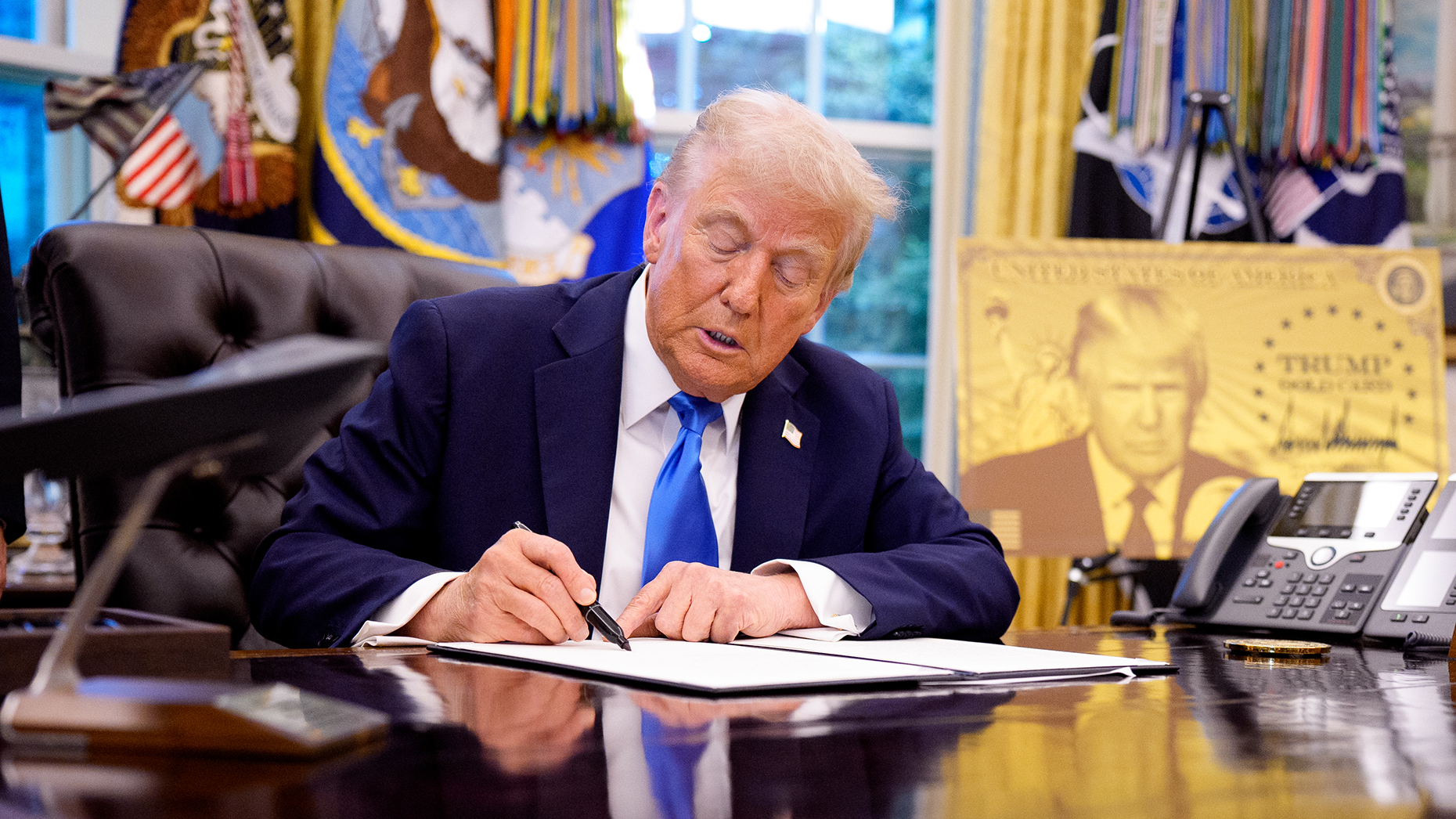  President Donald Trump signs an executive order introducing a $100,000 fee for H-1B visas. Photo via Getty.