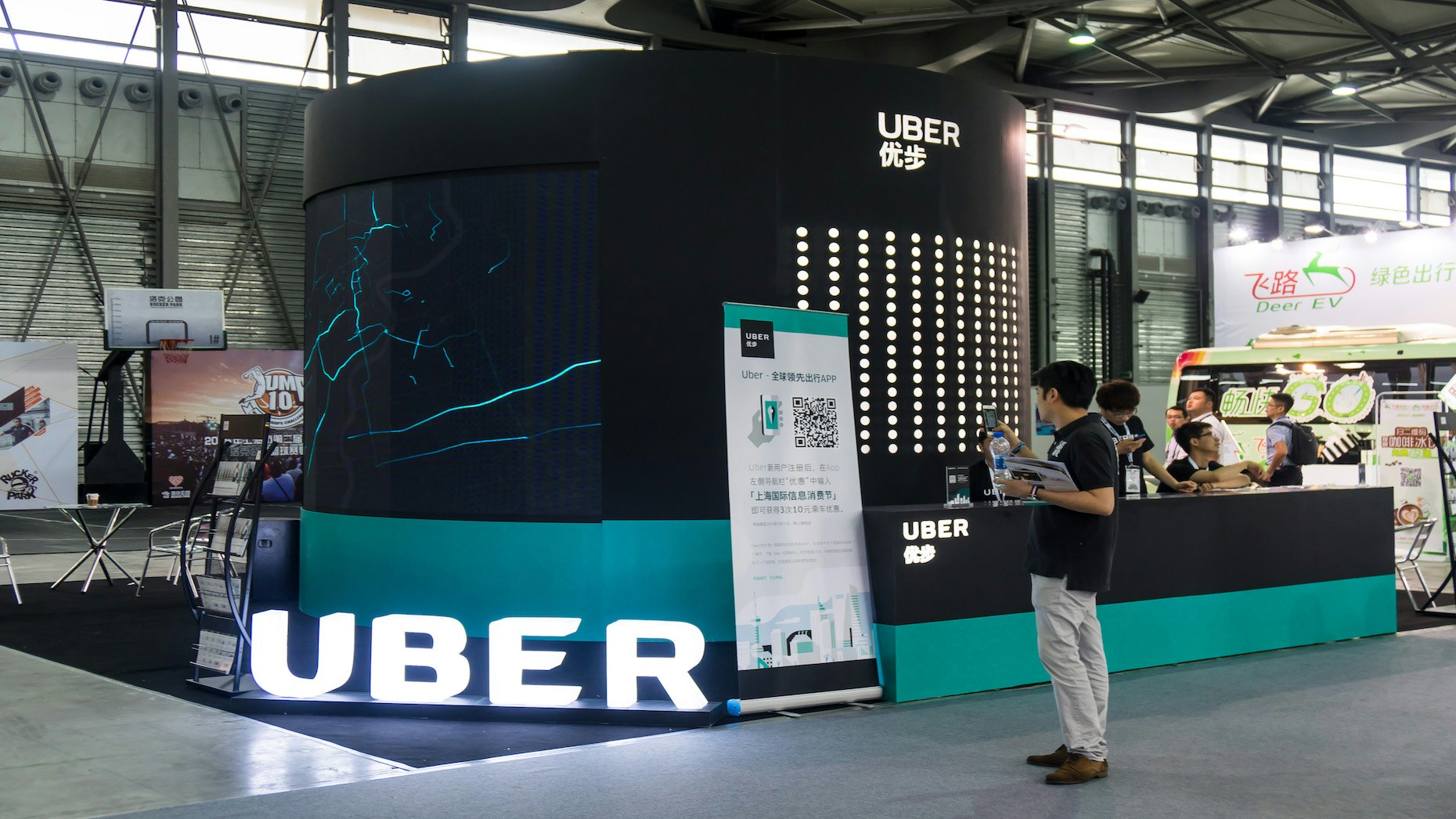 A visitor in front of the Uber stand at the 2016 Mobile World Congress in Shanghai. Photo by The Associated Press.