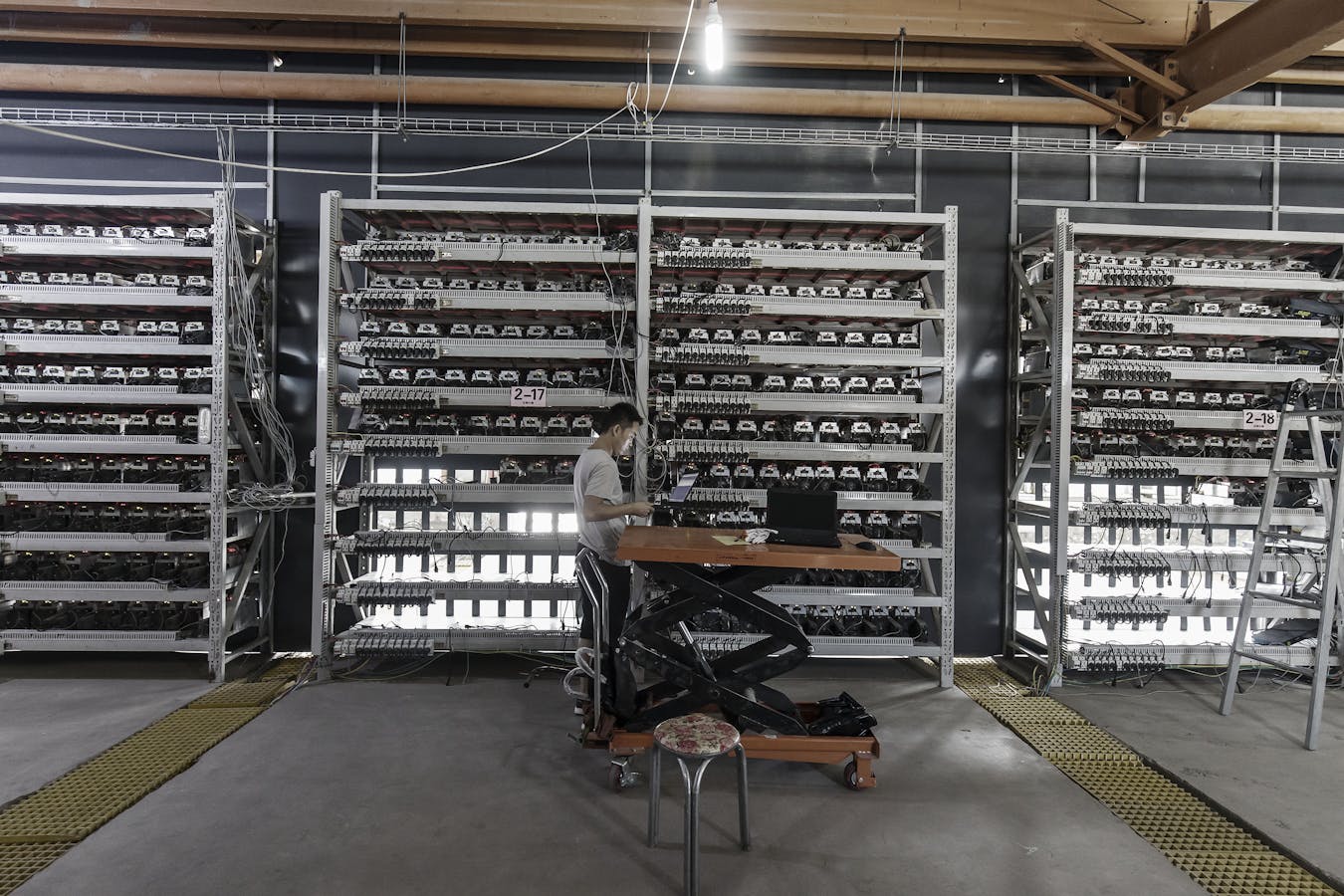 A worker inspects bitcoin mining machines at a facility in Ordos, Inner Mongolia, China. Photo: Bloomberg