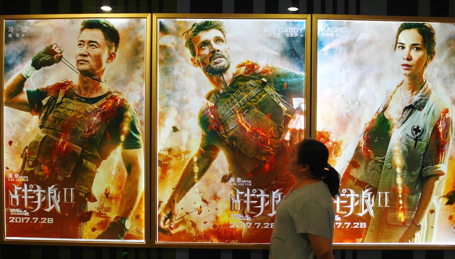 A Chinese filmgoer walks past posters of  "Wolf Warriors 2" at a cinema in Yichang city, central China's Hubei province, last August. Photo by AP.