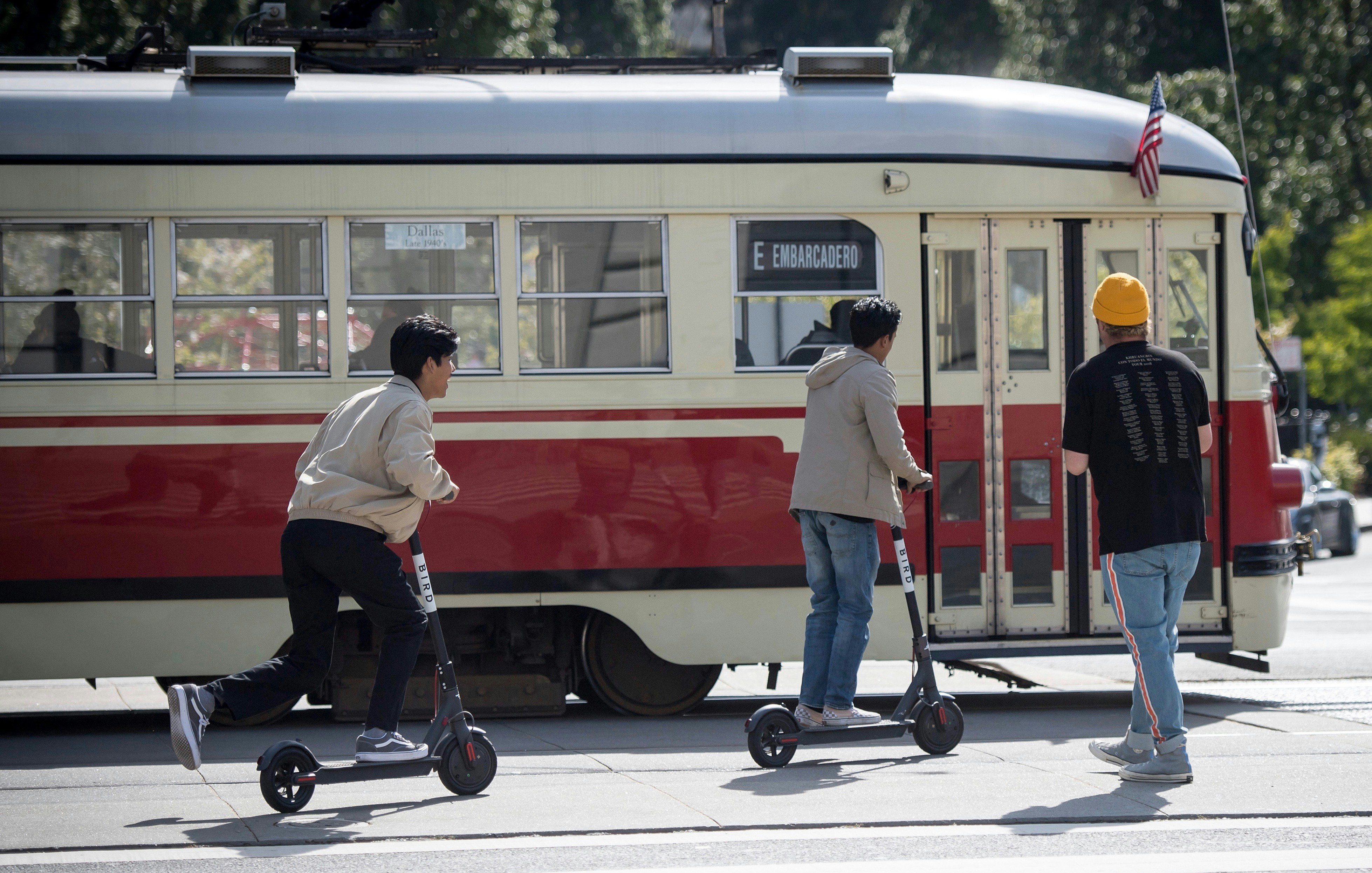 People riding scooters in downtown San Francisco. Photo by Bloomberg