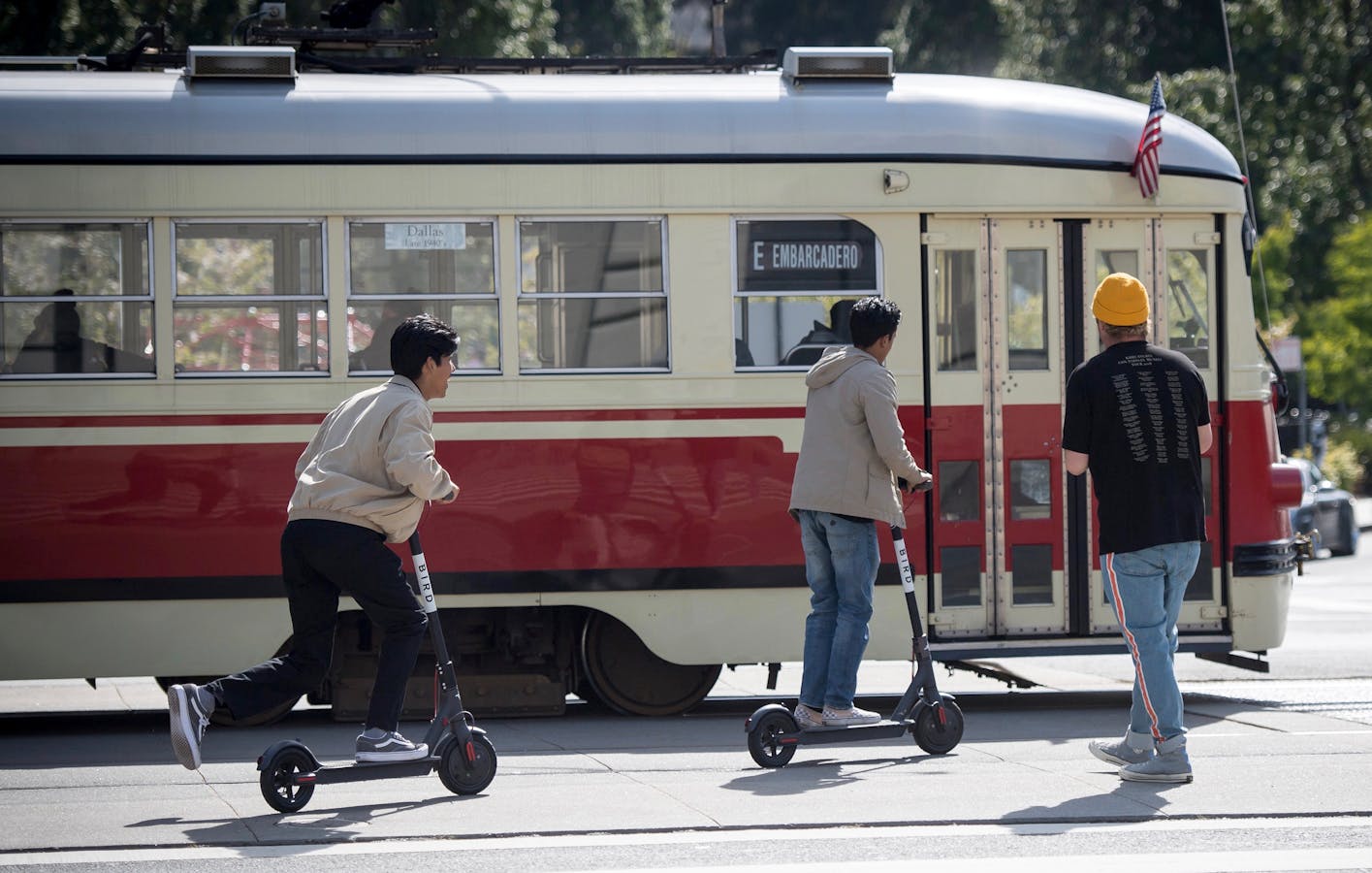 People riding scooters in downtown San Francisco. Photo by Bloomberg