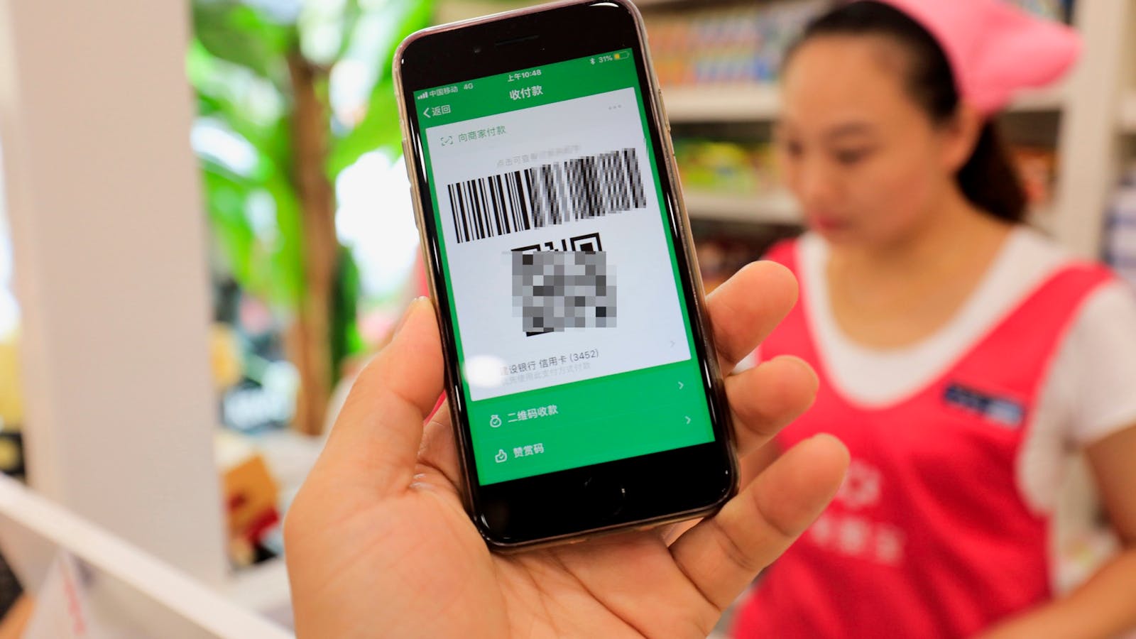 A local resident in Shanghai used a smartphone to have the QR code scanned through Tencent's WeChat Pay. Photo: AP 