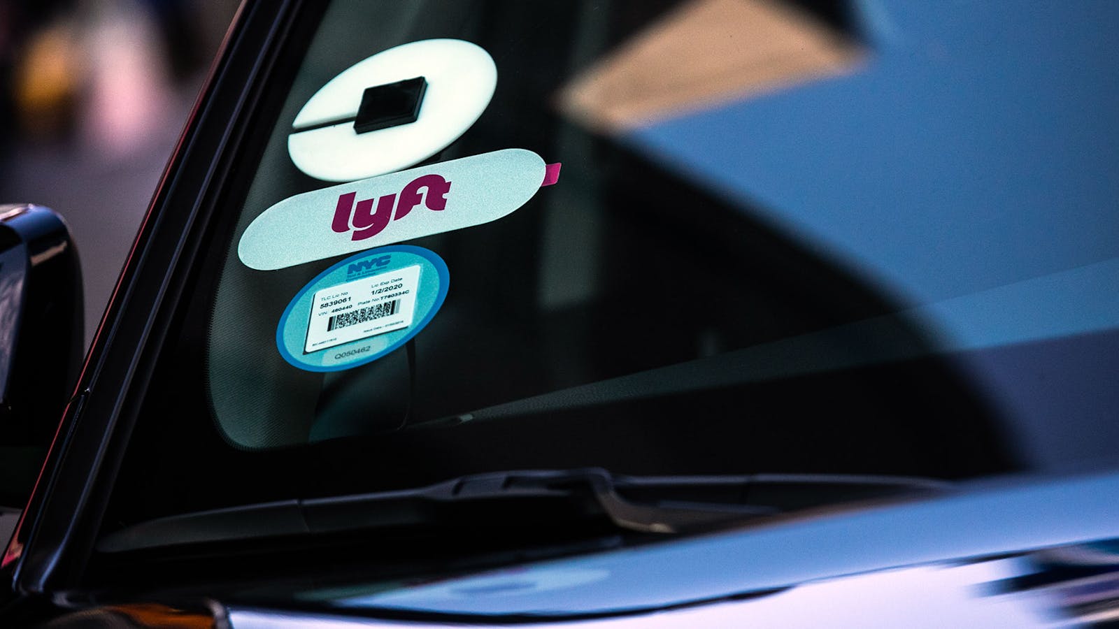 Uber and Lyft stickers are displayed on a vehicle in New York. Photo by Bloomberg.