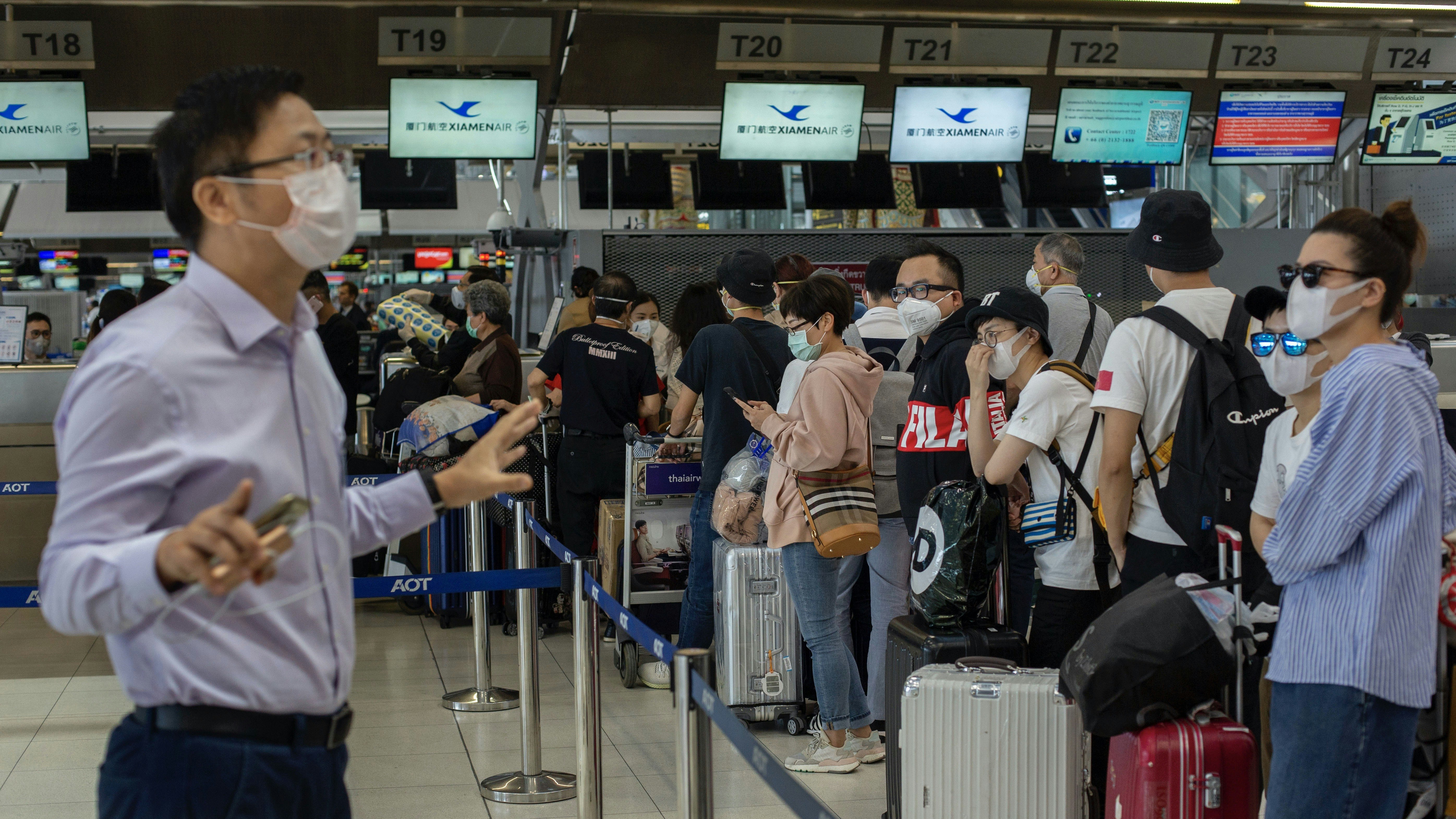 An airport official in Thailand talking to people flying to Wuhan this week. Photo by AP