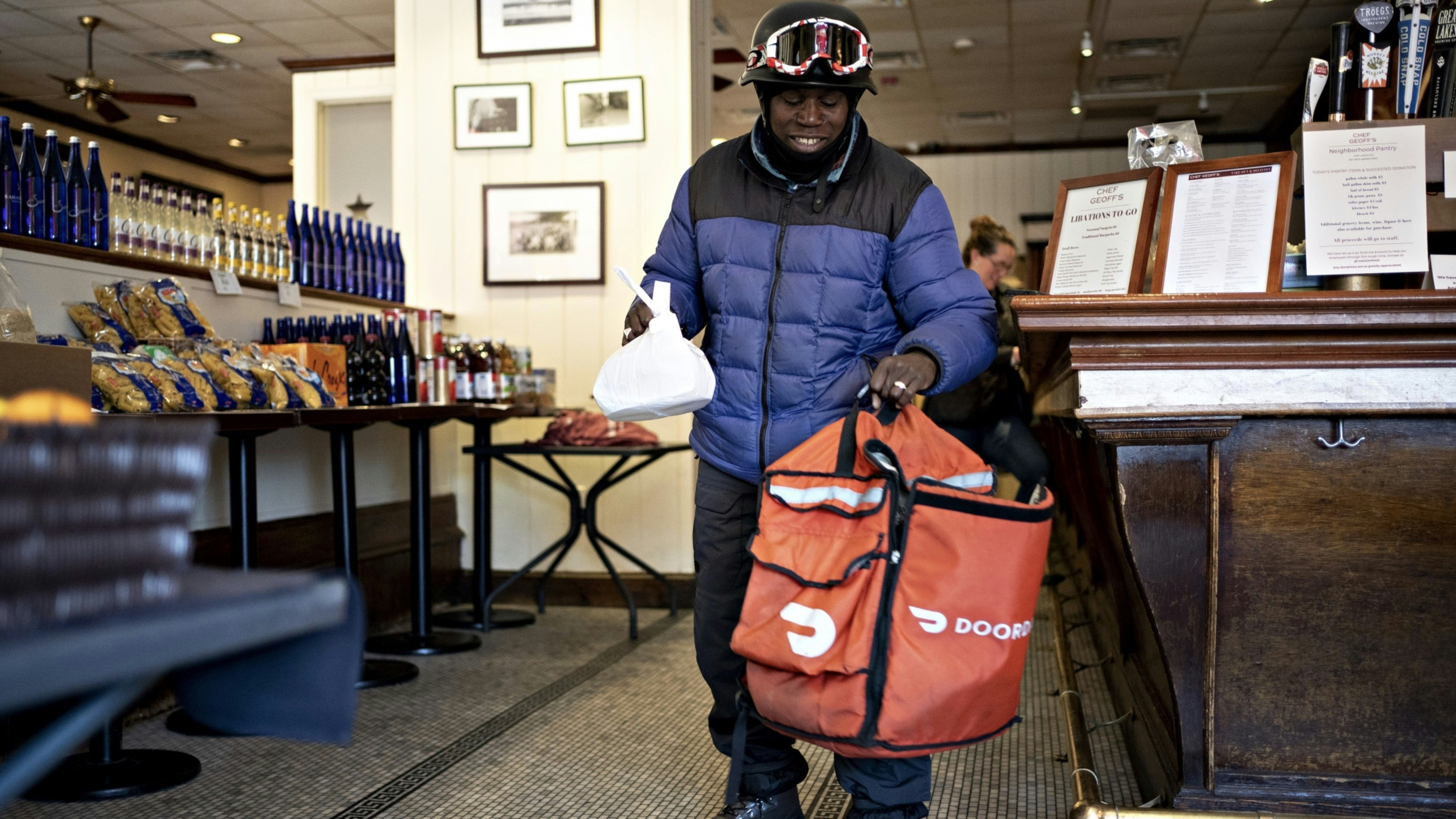 A DoorDash delivery person picking up an order in Washington D.C. Photo by Bloomberg.