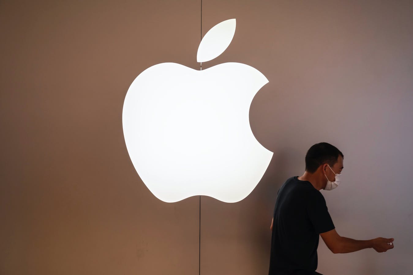 A pedestrian walks past an Apple retail store in Shenzhen. In recent months, Apple has resumed sending some U.S. employees to China to meet with its manufacturing partners. Photo: Associated Press