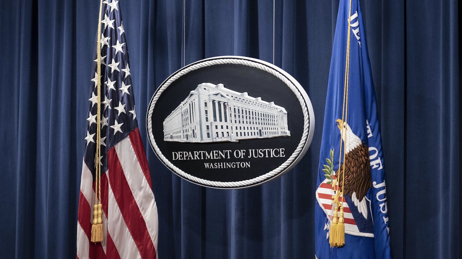 The Justice Department's sign at a press conference. Photo by Bloomberg