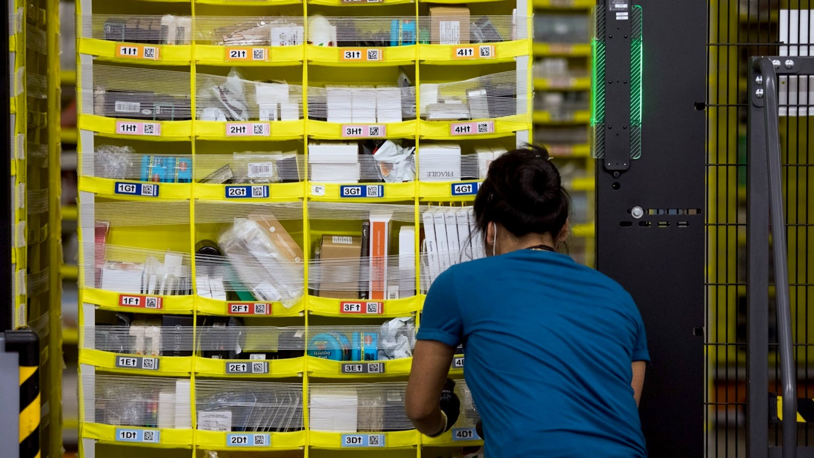 A worker at a picking station at an Amazon warehouse. Photo by Bloomberg