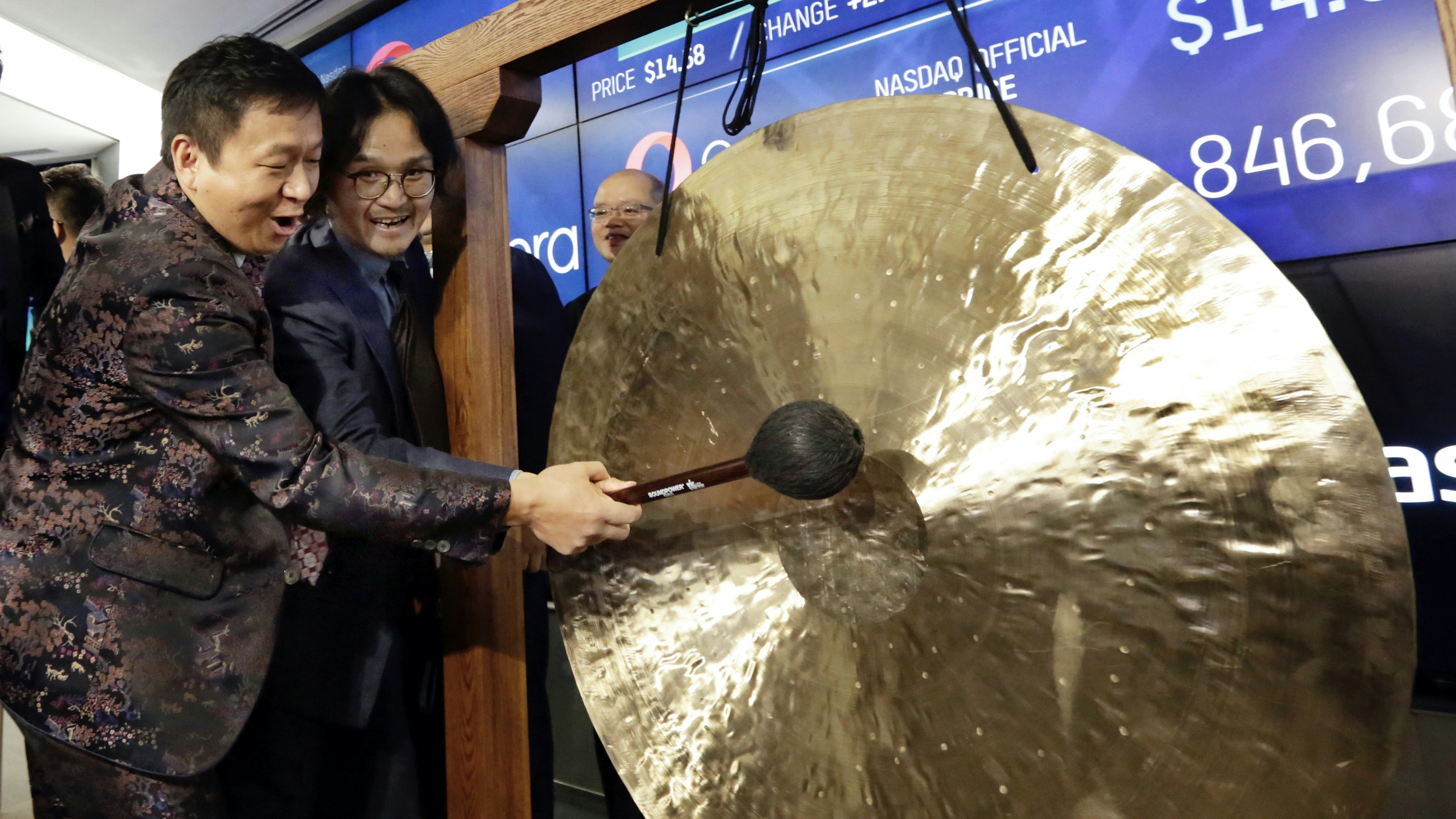 Opera Chairman & CEO Yahui Zhou and Executive Vice President Jiwei Wu ring a gong as Opera begins trading at the Nasdaq  in 2018. Photo by AP