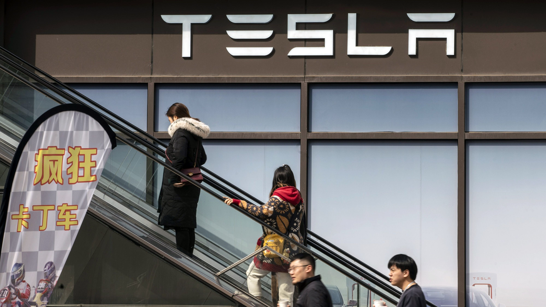 Shoppers in front of the Tesla showroom at a shopping plaza in Shanghai, China, in March. Photo by Bloomberg.