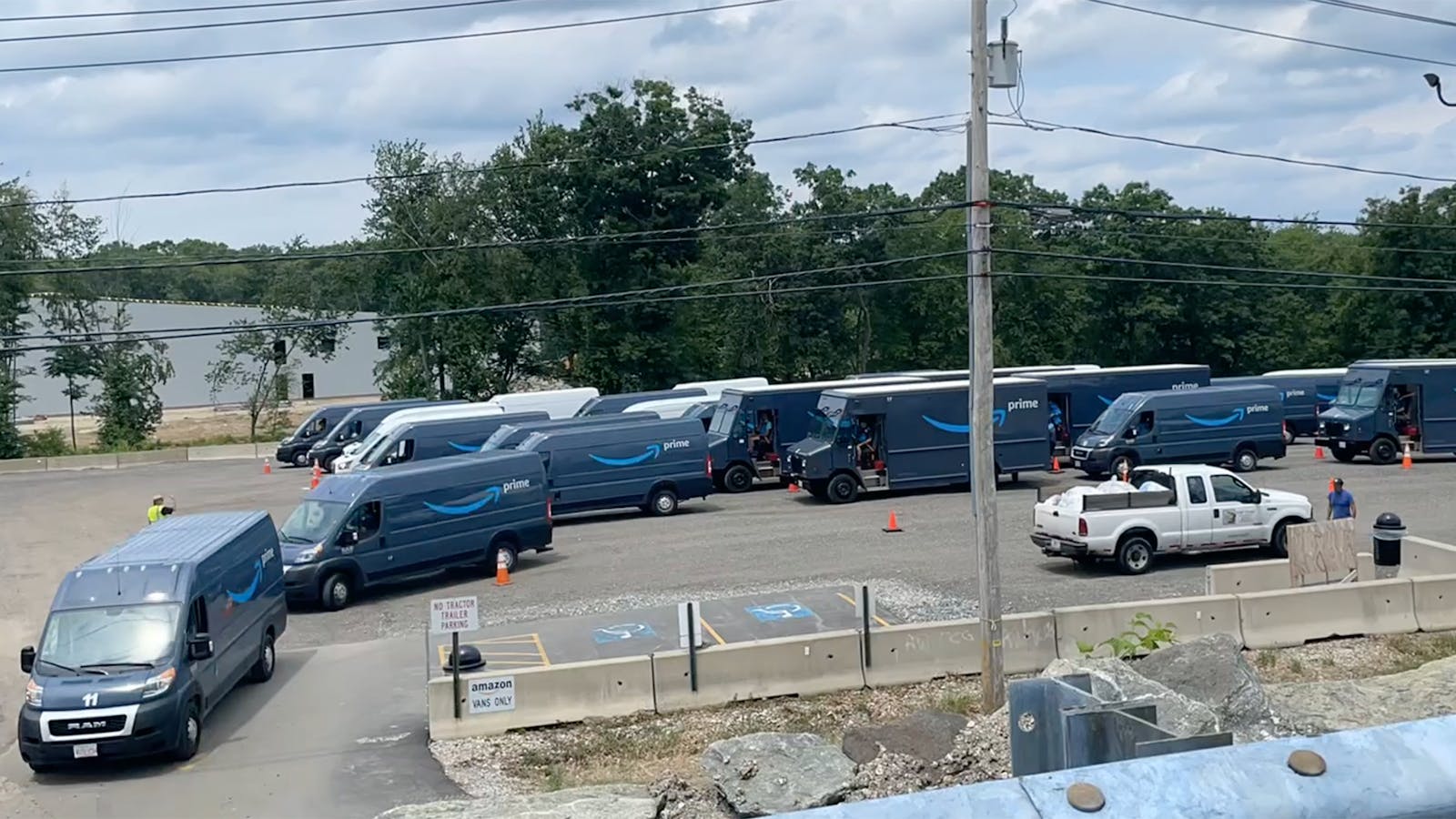 Amazon vans departing a new staging lot outside an Amazon delivery station in Milford, Mass. Photo by Paris Martineau