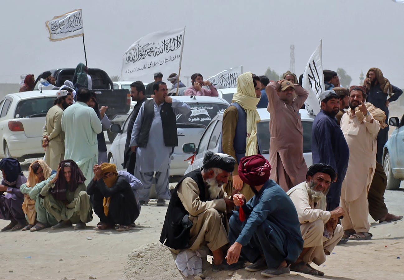 People near Taliban signature white flags at a border crossing point in Pakistan on Aug. 17. Photo: AP