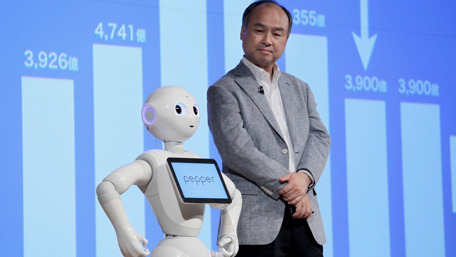 SoftBank founder Masayoshi Son stands next to a robot. Photo by Bloomberg.