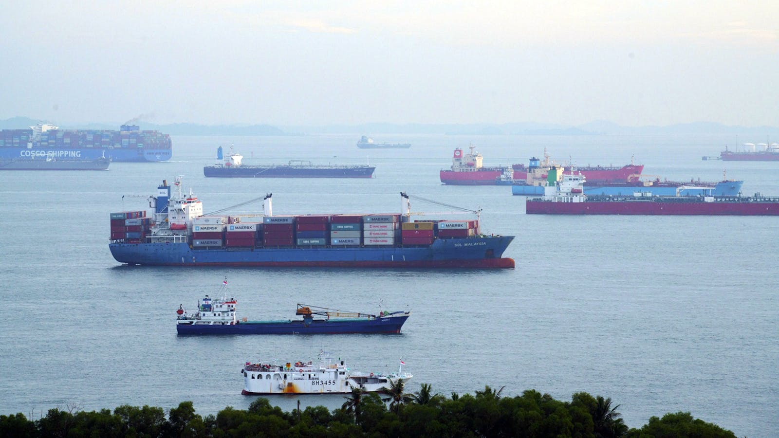 Container ships and bulk carriers offshore from Singapore. Photo by Bloomberg