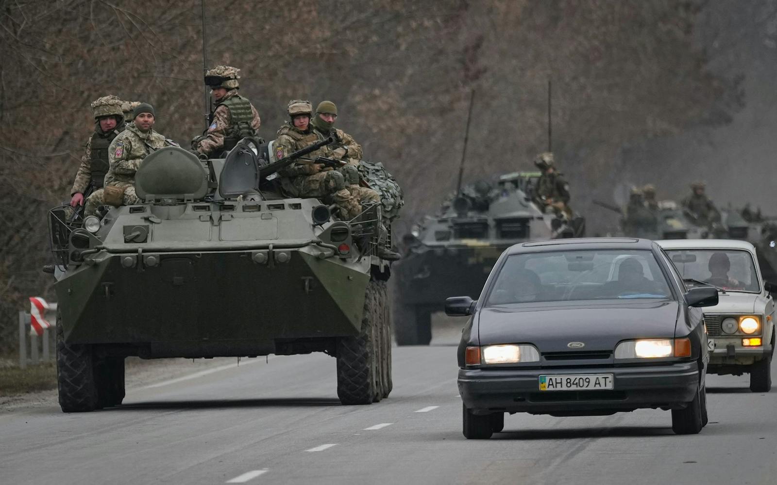 Ukrainian servicemen sit atop armored personnel carriers driving on a road in the Donetsk region, eastern Ukraine on Feb. 24, 2022. Photo: AP