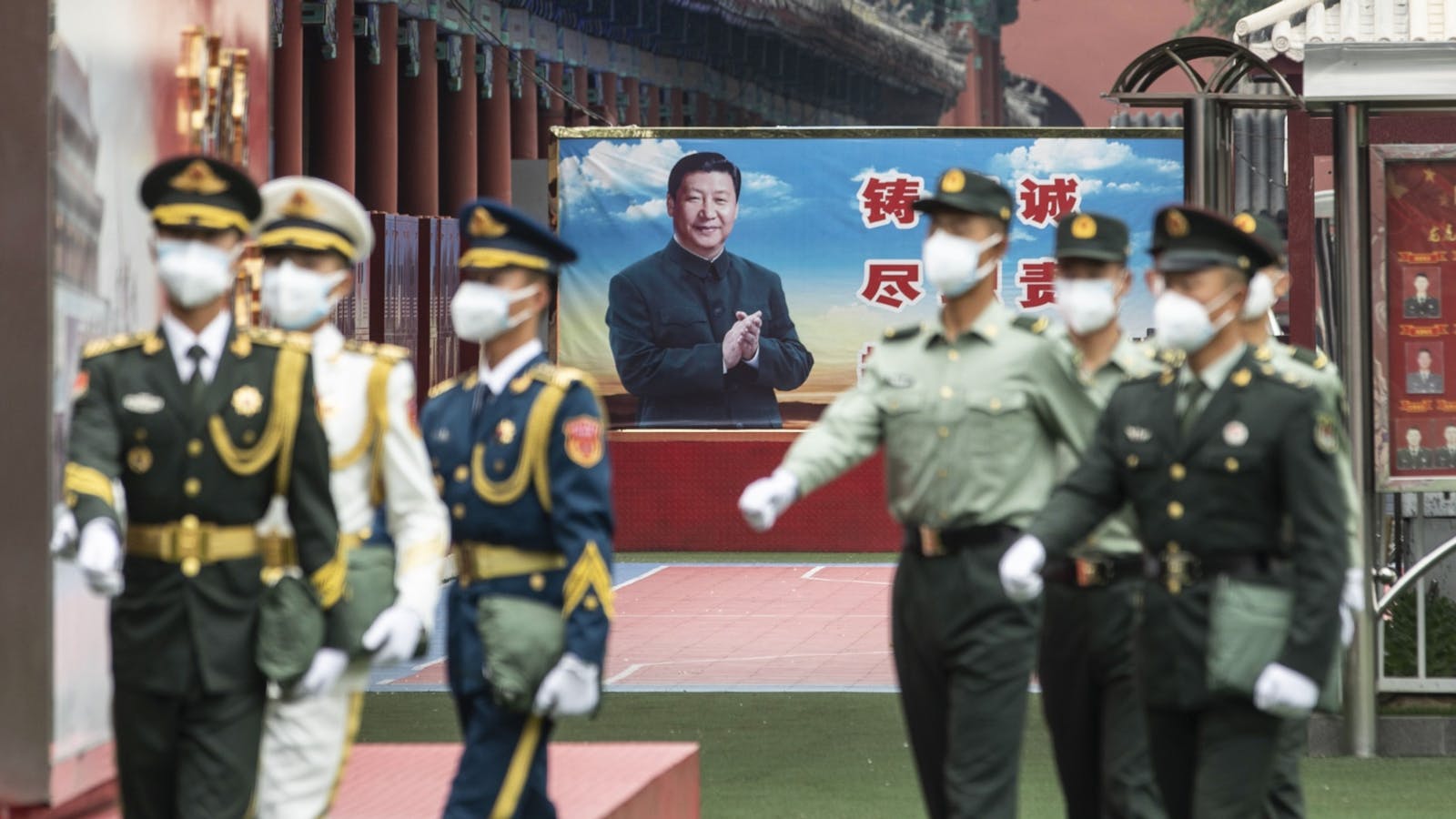 People's Liberation Army personnel near a banner of Chinese president Xi Jinping in Beijing, 2020. Photo by Bloomberg