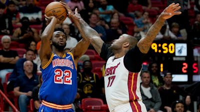 Golden State Warriors' Andrew Wiggins (22) and Miami Heat's P.J. Tucker (17) in a game in March. Photo by AP