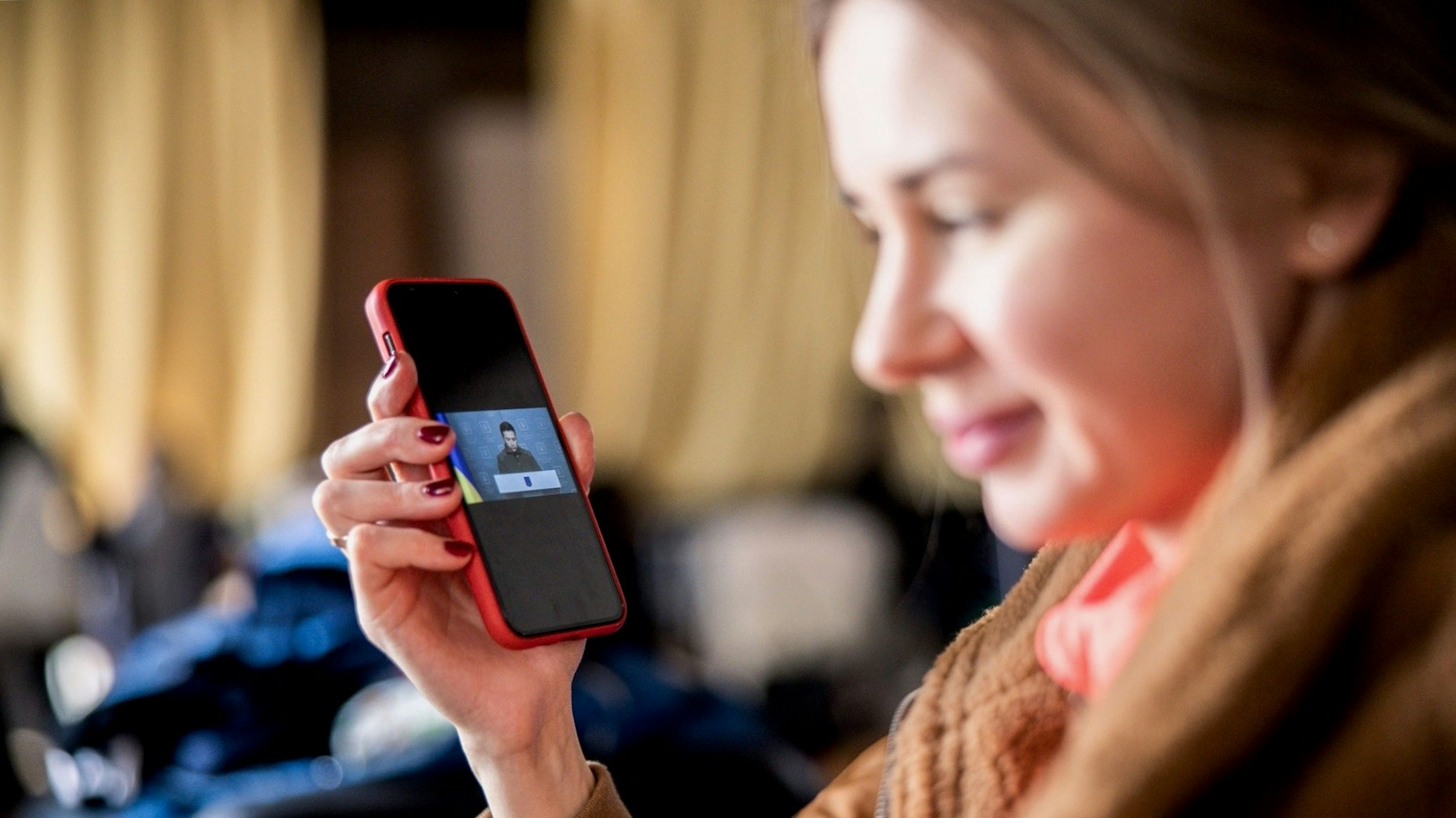 A displaced Ukrainian listens to the speech of Ukrainian President Zelensky at a temporary shelter in Hungary in February. Photo: Bloomberg