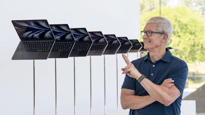 Apple CEO Tim Cook posing next to a line of new M2 MacBook products. Photo: Bloomberg.
