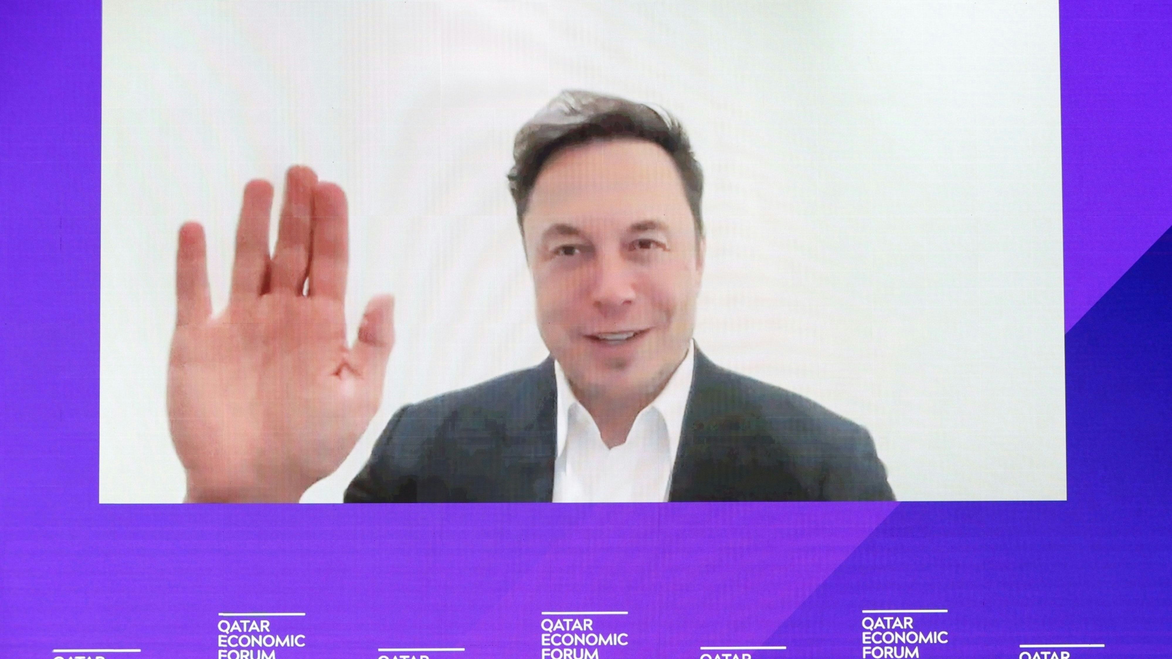 Elon Musk appearing via video at a conference in Qatar in June. Photo by Bloomberg